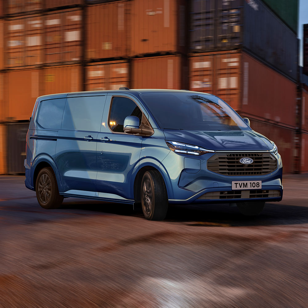 Modrý Ford Transit Custom Plug-in Hybrid projíždí přístavištěm.