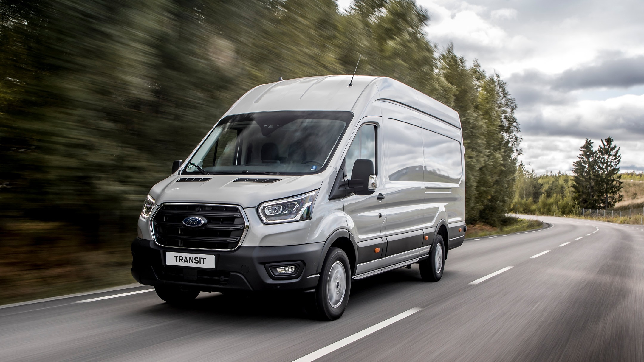 Stříbrný Ford Transit v jízdě