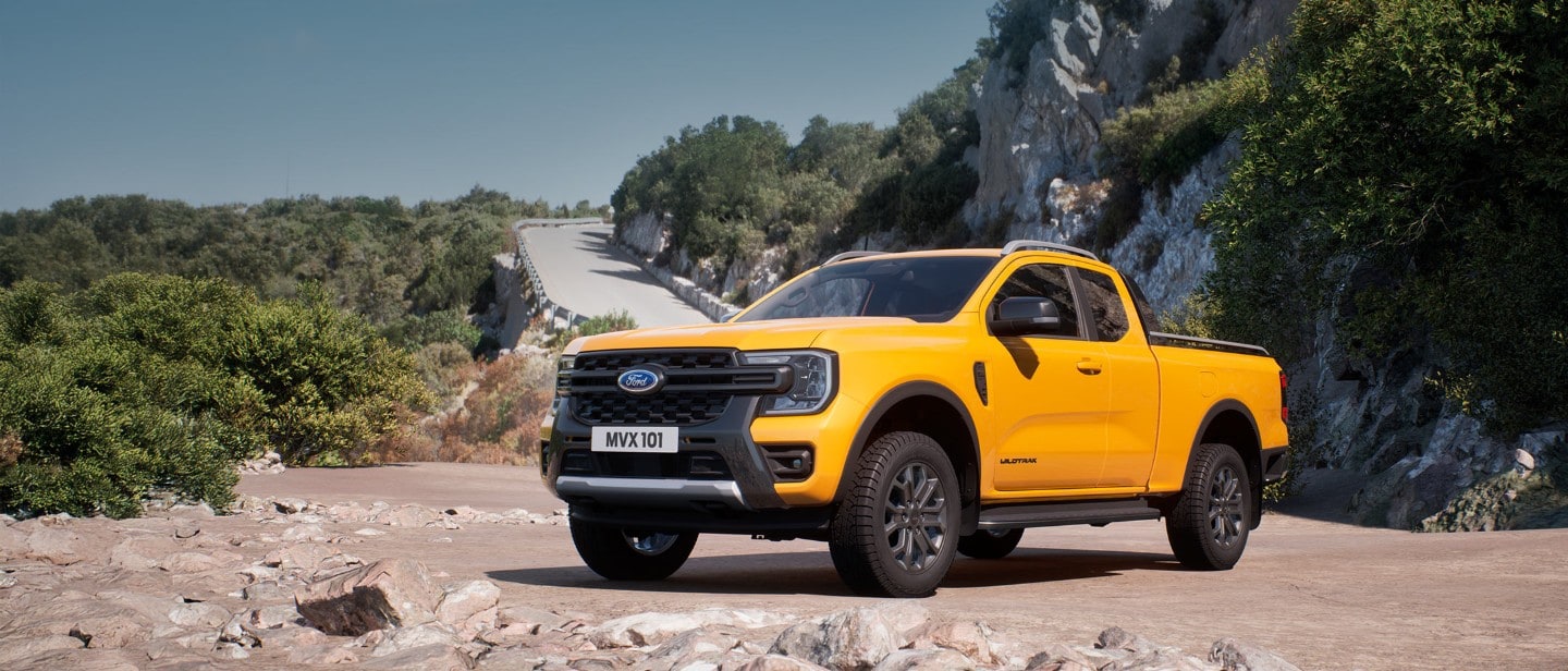Žlutý Ford Ranger Wildtrak z částečného pohledu zepředu, zaparkovaný na kamenité cestě