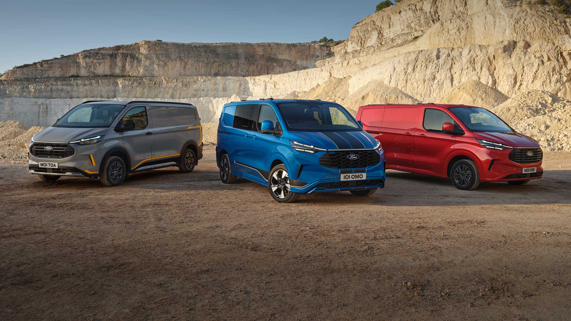 Řada dodávek Ford Transit Custom v různých provedeních a barvách, zaparkovaných v lomu.