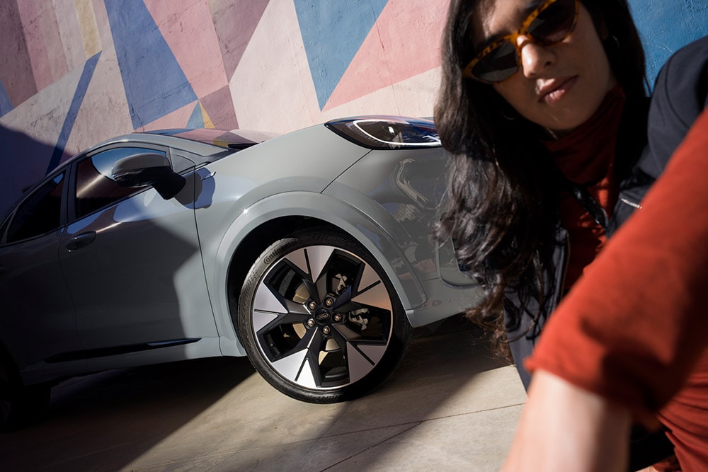 Pohled zblízka na člověka stojícího vedle šedého Fordu Puma® s benzínovým motorem EcoBoost®. 