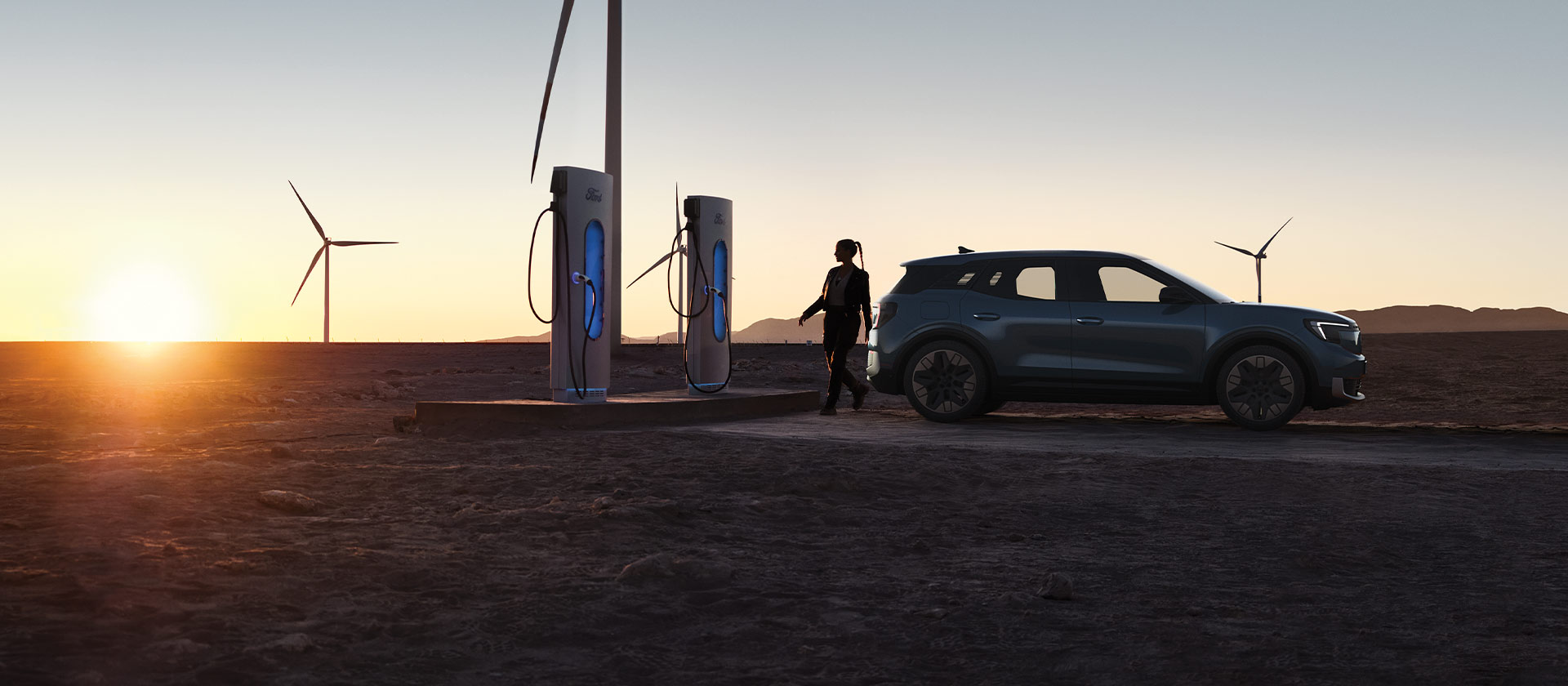  A woman charging a Ford electric car at a public EV charging station.