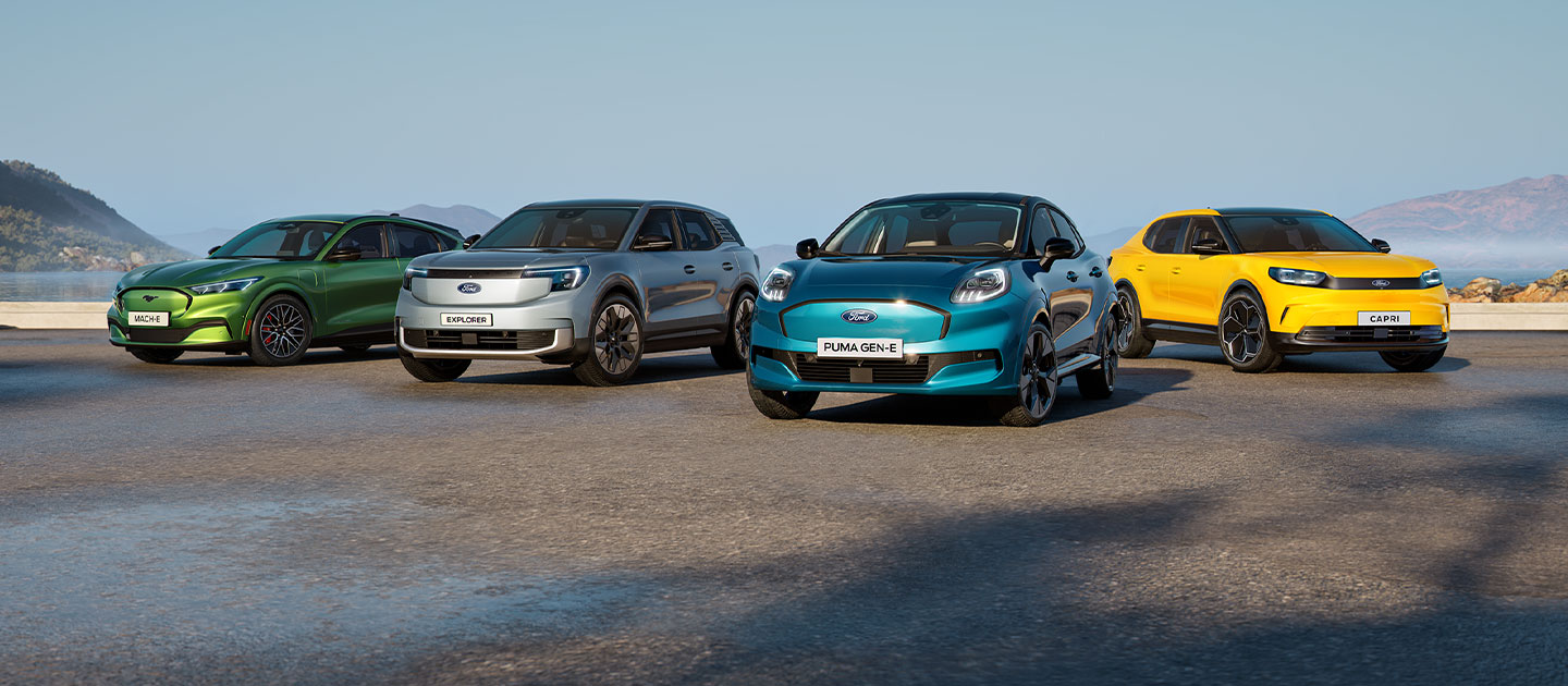 Několik různých elektromobilů Ford parkuje na členitém pobřeží.