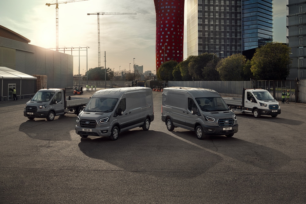 Řada elektrických a plug-in hybridních dodávek Ford na venkovním parkovišti.