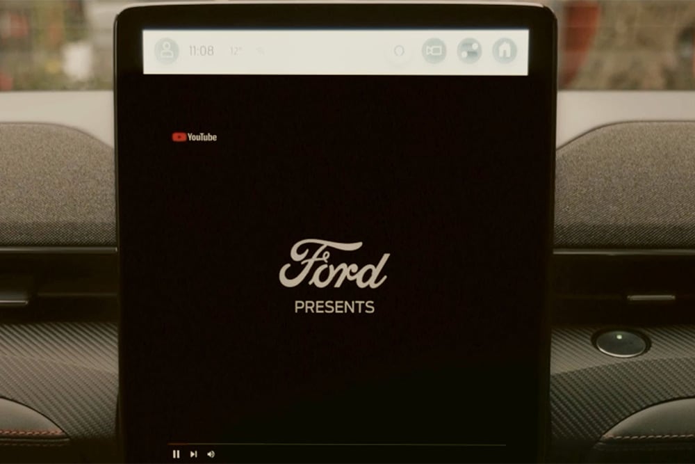 Detailní záběr na 15,5" dotykovou obrazovku SYNC 4 s grafickým nápisem „Ford presents“ upozorňuje na možnost streamování videa ve voze