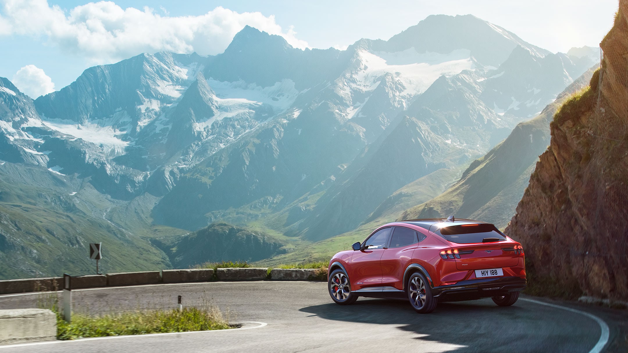 Červený Ford Mustang Mach-E na silnici v horách
