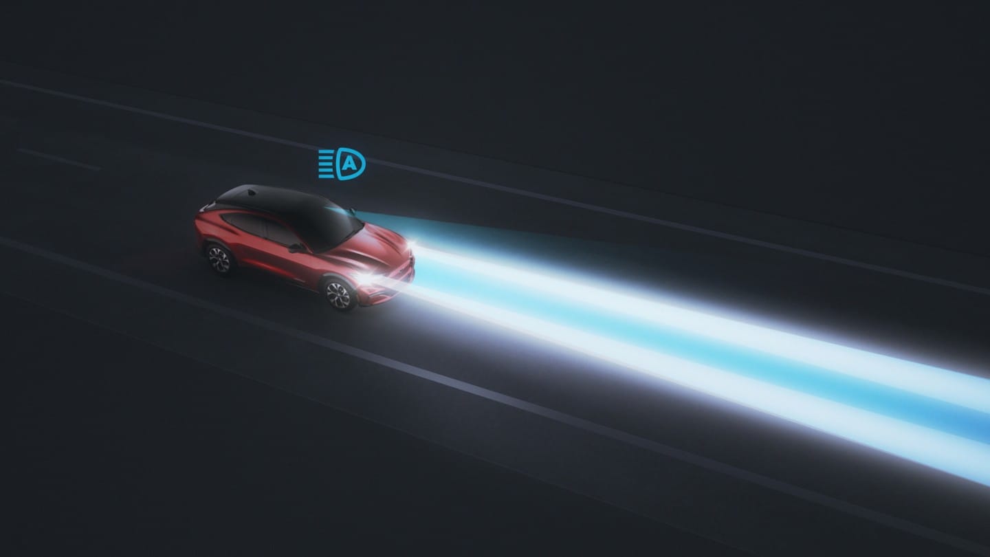Nový Ford Mustang Mach-E jedoucí ve tmě s automatickými dálkovými světly