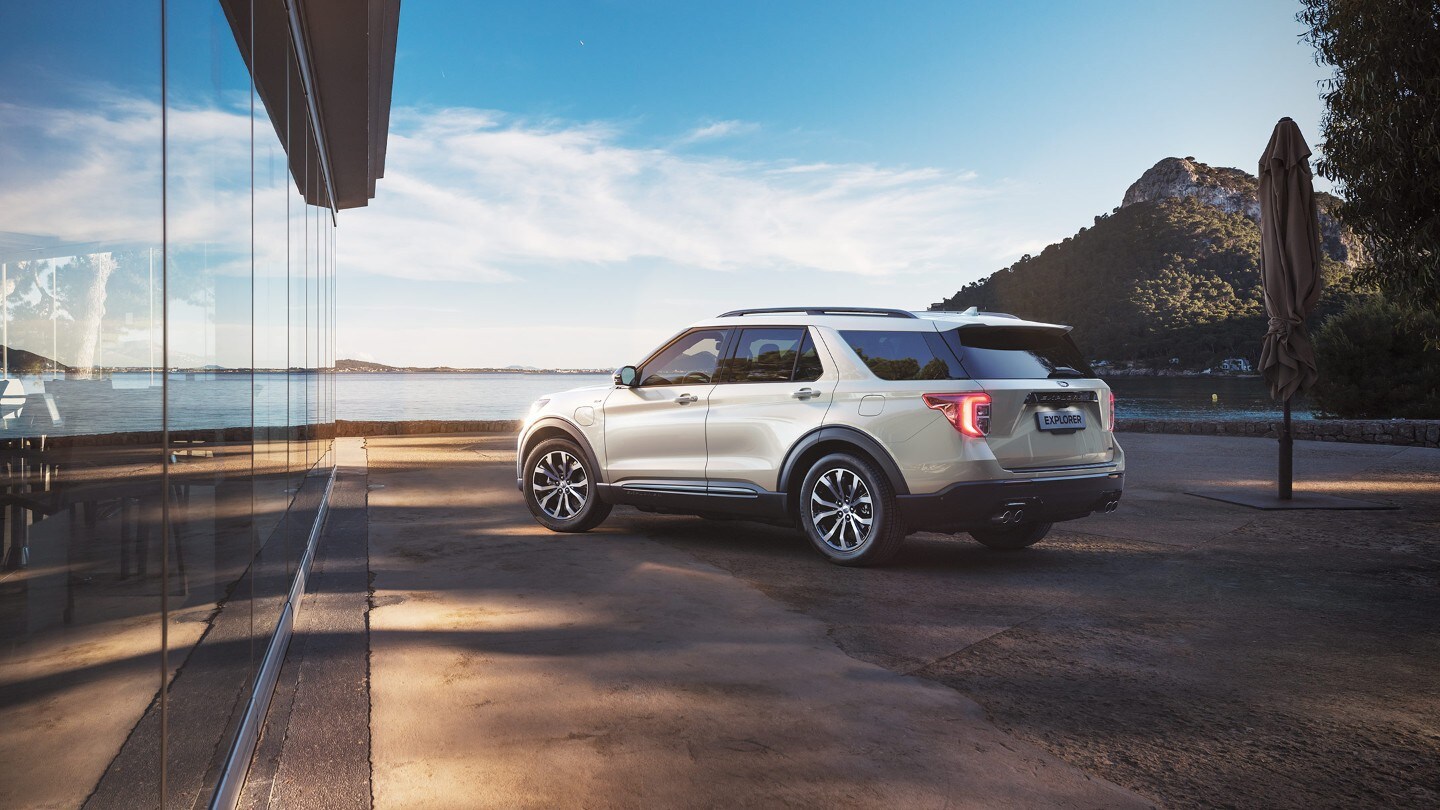 Ford Explorer parked by the lake 3/4 back view