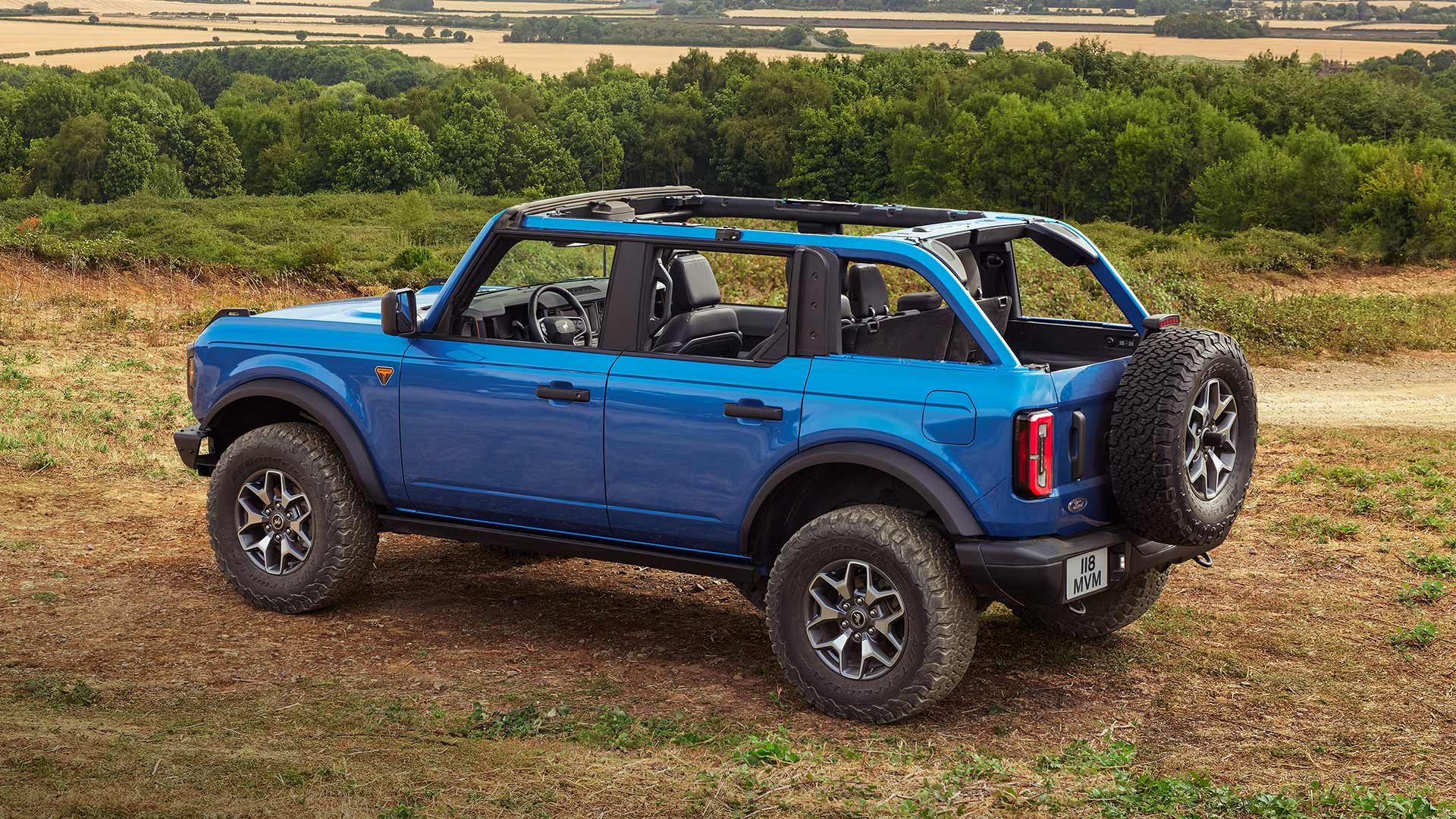 Zadní pohled na modrý Ford Bronco s náhradním kolem na zadní straně.