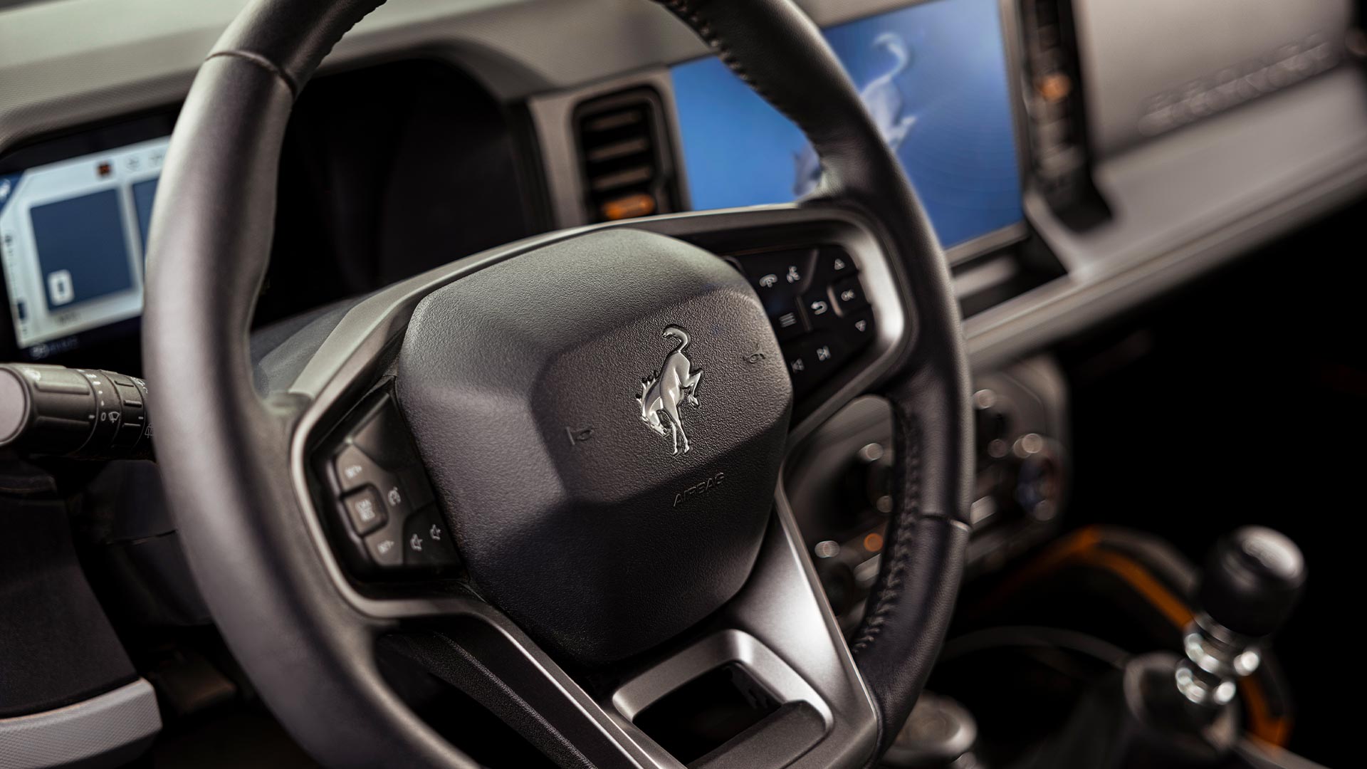 Detailní záběr na značkový kožený volant Fordu Bronco.