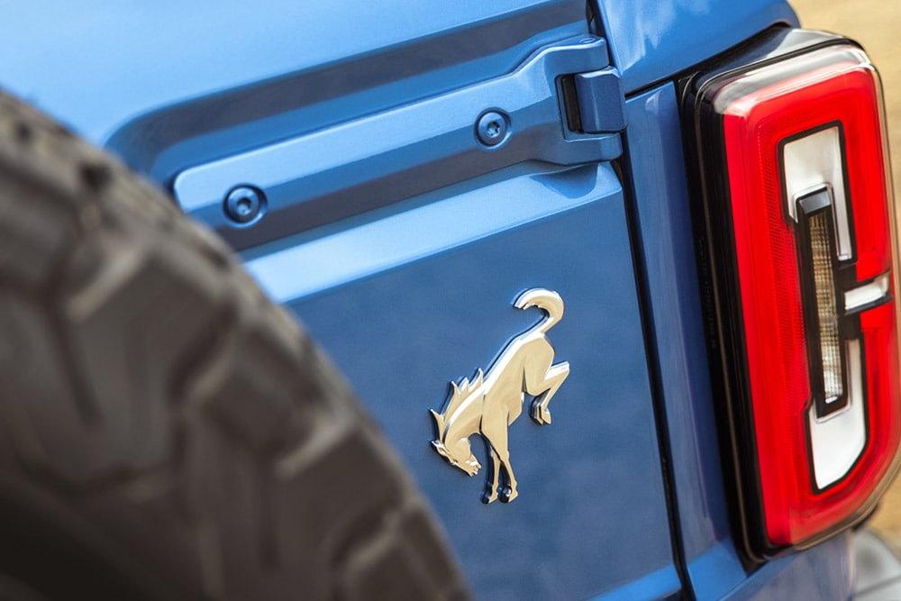 Detailní záběr na značkové detaily na zadní straně modrého Fordu Bronco.