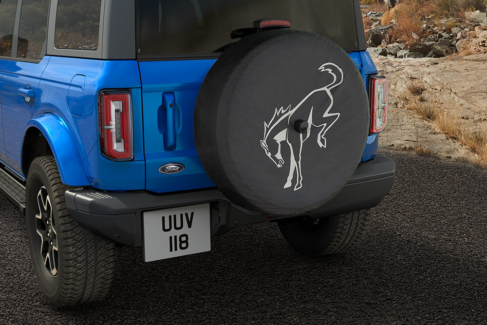 Zadní pohled na modrý Ford Bronco s náhradním kolem na zadní straně.