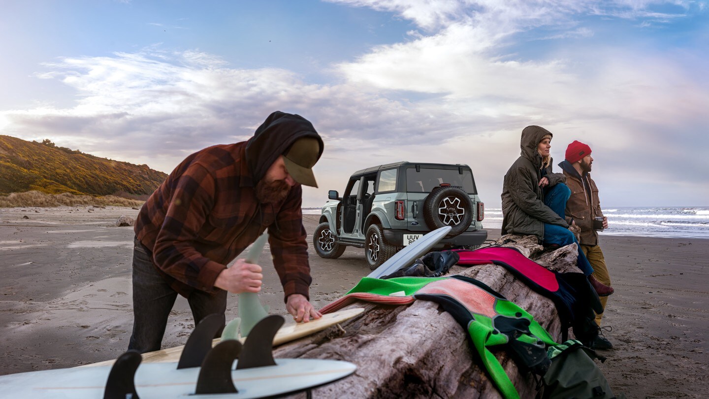 Ford Bronco na pláži se surfaři