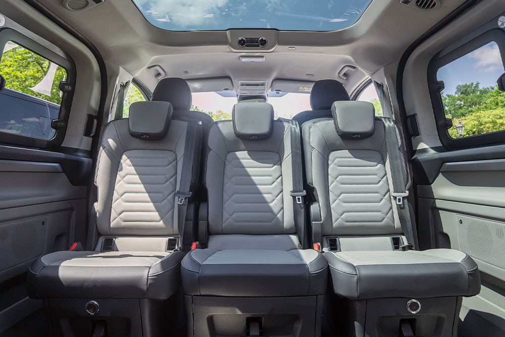 Pohled do interiéru vozu Ford Tourneo Custom se sedadly v konferenčním uspořádáním a s panoramatickou střechou.