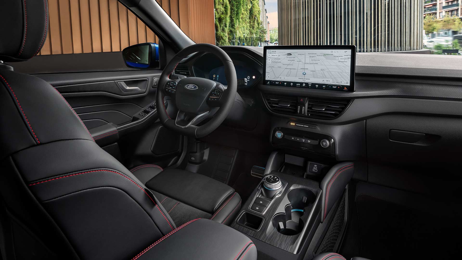 Interiér Fordu Kuga s logem Ford na volantu, velkou dotykovou obrazovkou SYNC® 4 a černými sedadly s červeným prošíváním.