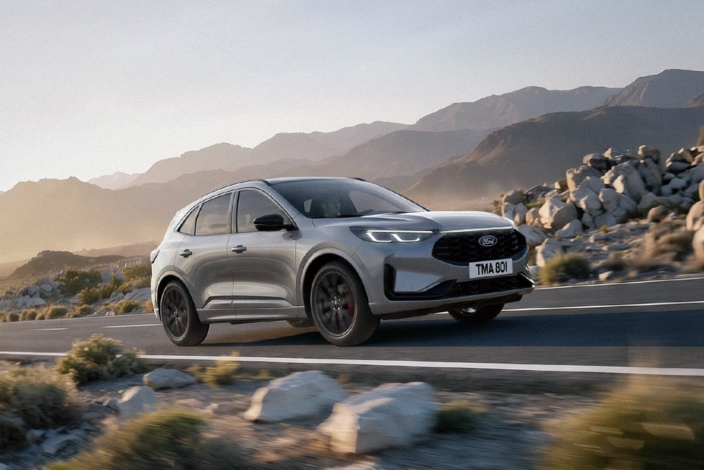 Stříbrný Ford Kuga v horské, skalnaté krajině.