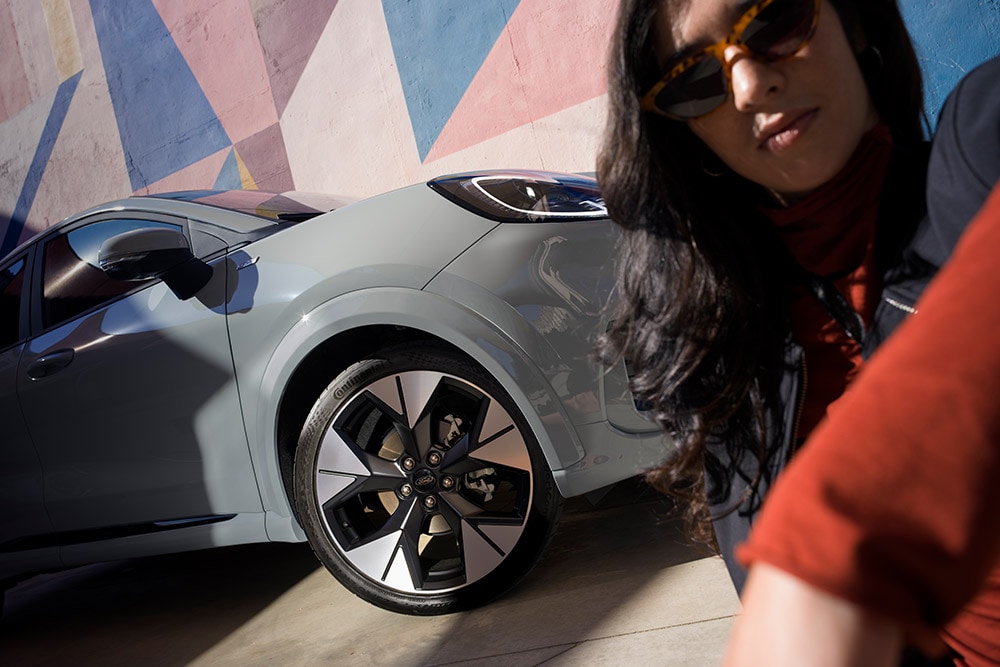 Pohled zblízka na člověka stojícího vedle šedého Fordu Puma® s benzínovým motorem EcoBoost®.