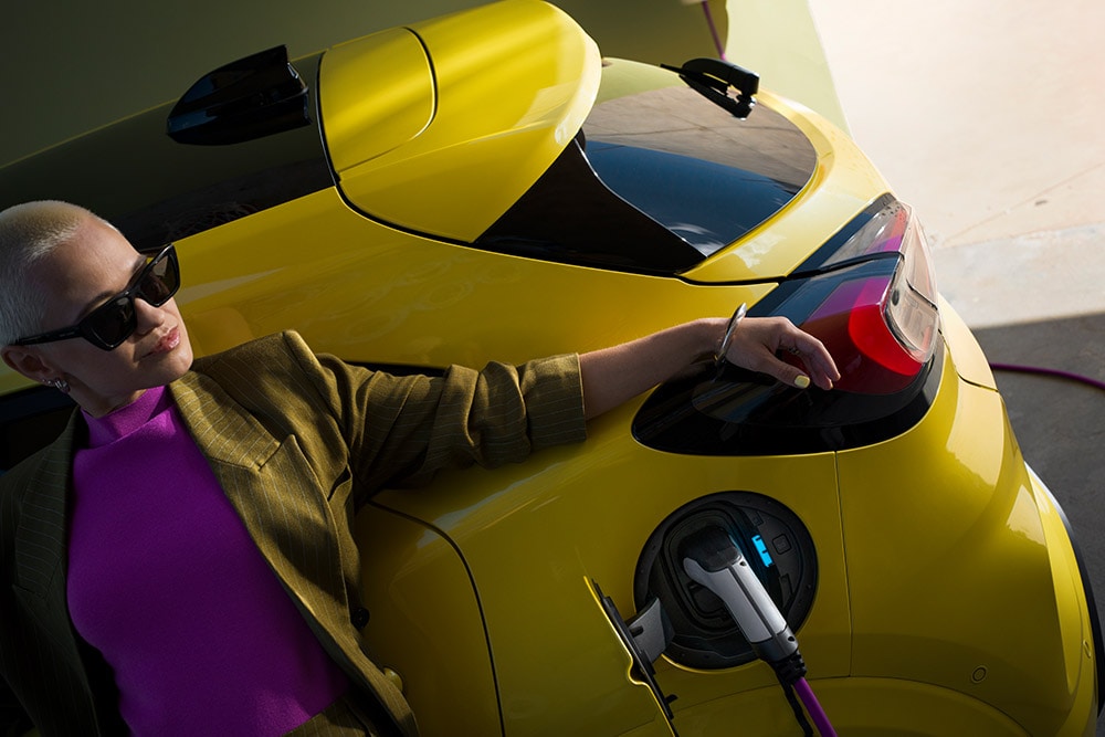 Pohled zblízka na zadní část elektrického Fordu Puma Gen-E® připojeného k domácí nástěnné nabíječce.
