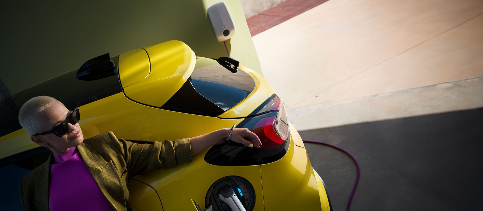 Člověk v interiéru elektrického Fordu Puma Gen-E bezdrátově synchronizuje mobil přes velkou dotykovou obrazovku.