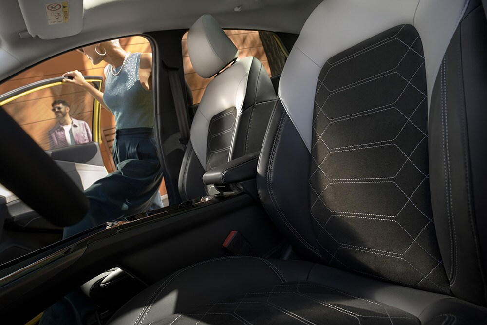 Pohled zblízka na černá a šedá ergonomická sedadla v elektrickém Fordu Puma Gen-E®.