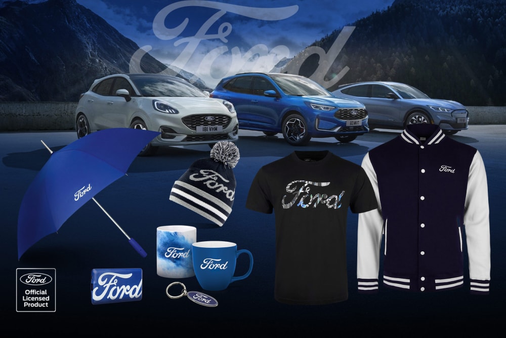 Kolekce doplňků Ford s různými vozidly Ford v pozadí s deštníkem, hrnky a oblečením značky Ford.