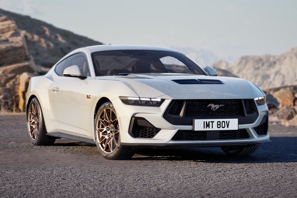 Ford Mustang GT Fastback s paketem Bronze Pack v barvě Oxford White zaparkovaný na horské silnici