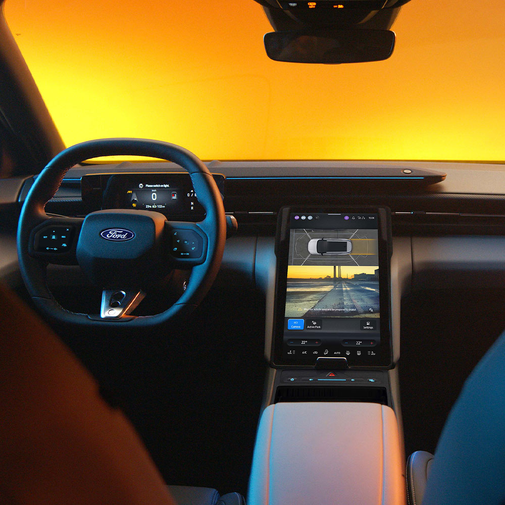 The Ford Capri® touchscreen displaying a split-screen view of the 360° camera system and parking assist guidelines.