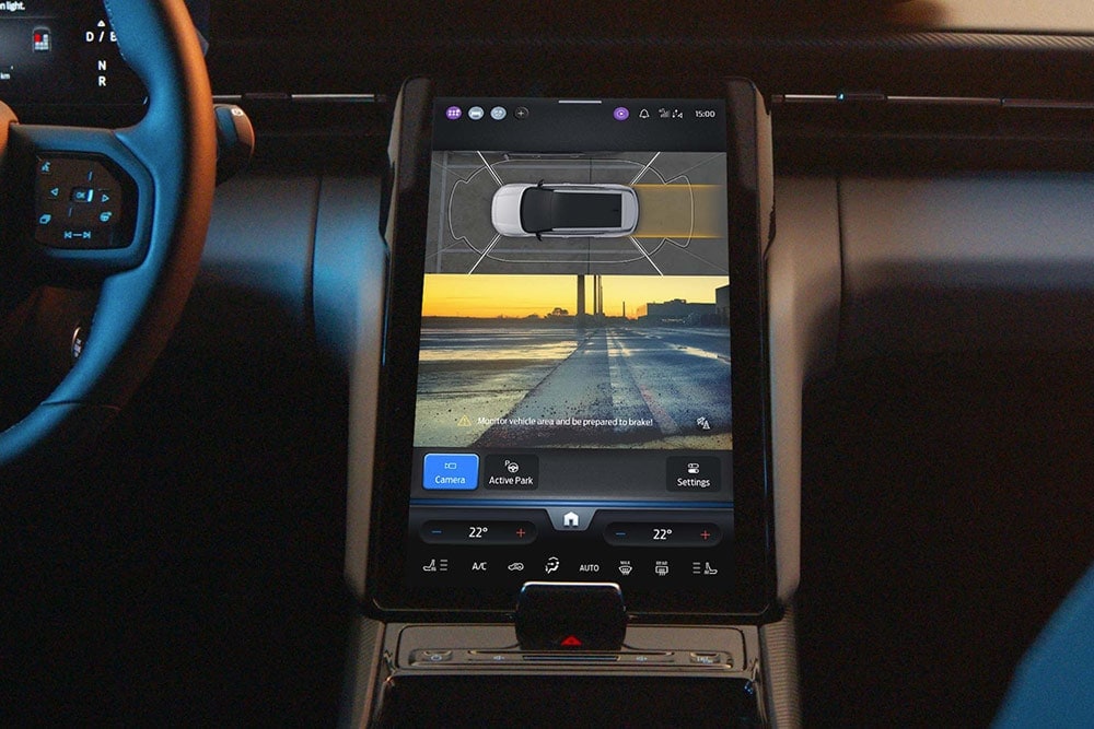 Detailní záběr na digitální dotykový displej SUV Ford, kde je vidět aktivní parkovací asistent v provozu.