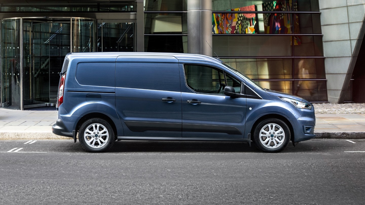 Blue Ford Transit Connect parked next to modern building