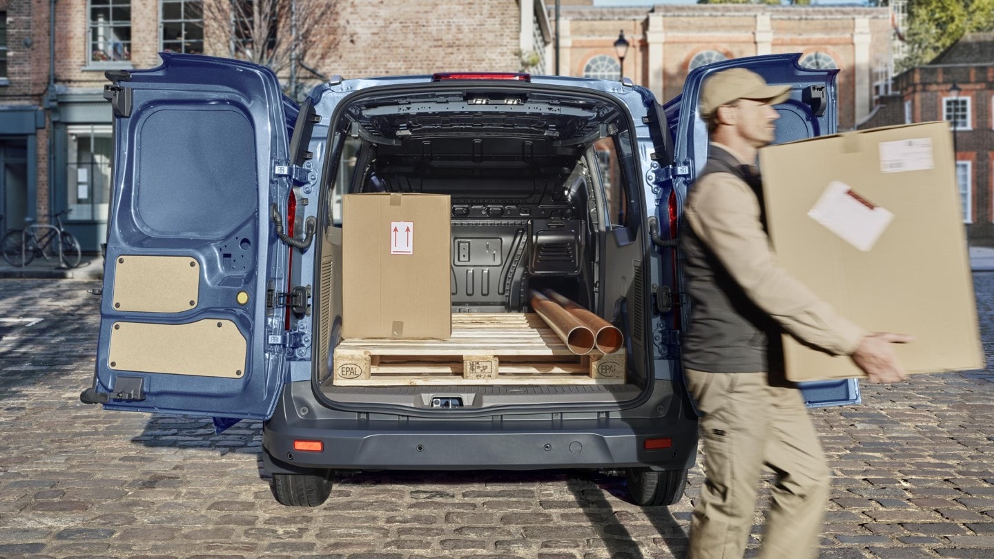 Ford Transit Connect with open back door and person moving boxes