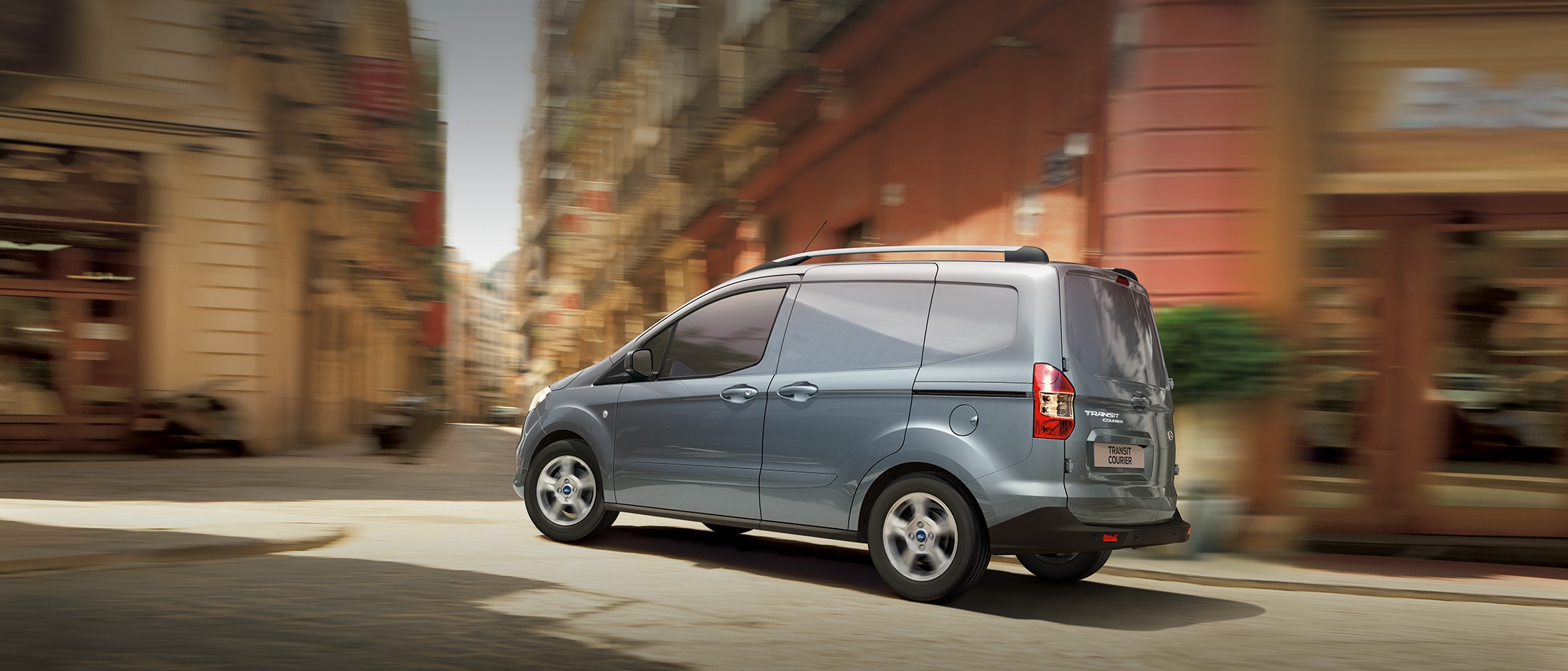 Light Blue Ford Transit Courier in city street