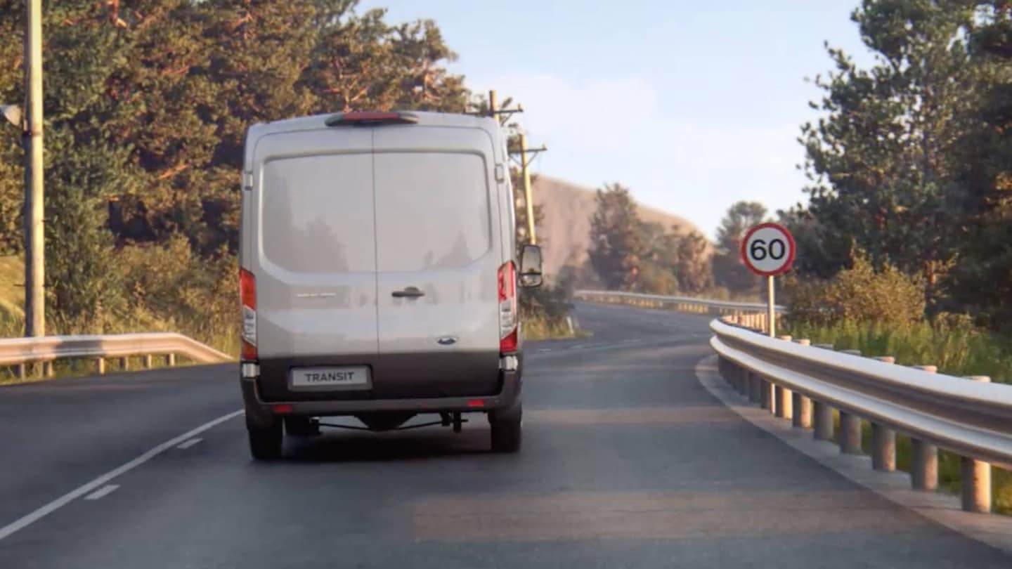 Ford Transit Vam driving on the road with traffic sign viewed from back