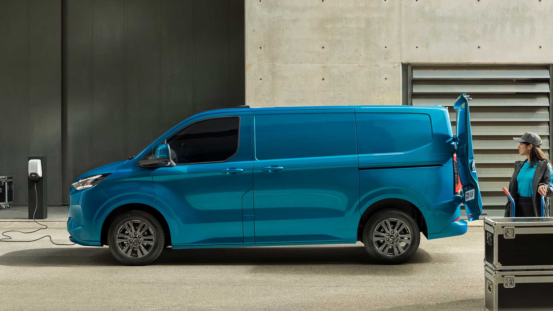Modrá elektrická dodávka Ford E-Transit Custom při nabíjení.