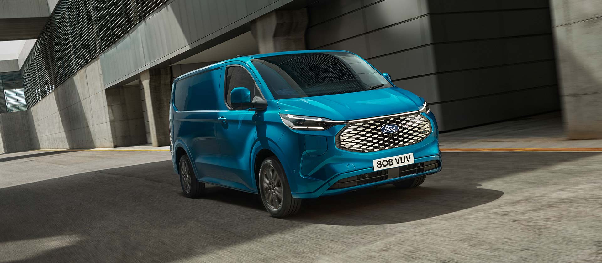 Boční pohled na modrou elektrickou dodávku Ford E-Transit Custom.