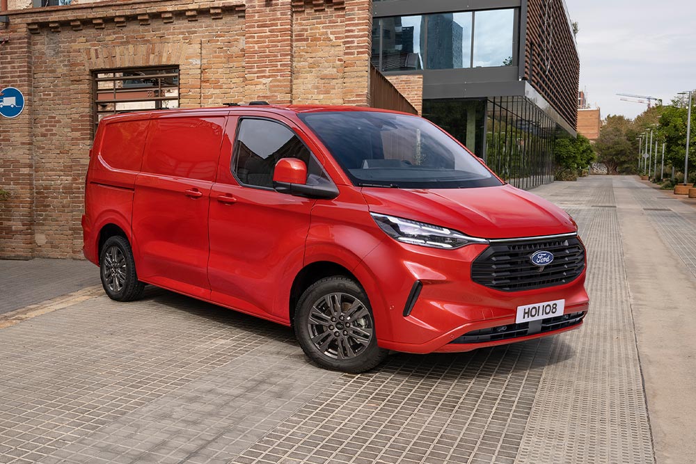 Červená dodávka Ford Transit Custom zaparkovaná na ulici.