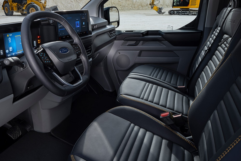 Interiér dodávky Ford Transit Custom Trail s černými sedadly se žlutými detaily.