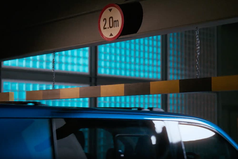 Modrá elektrická dodávka Ford E-Transit Custom vjíždí do garáže.