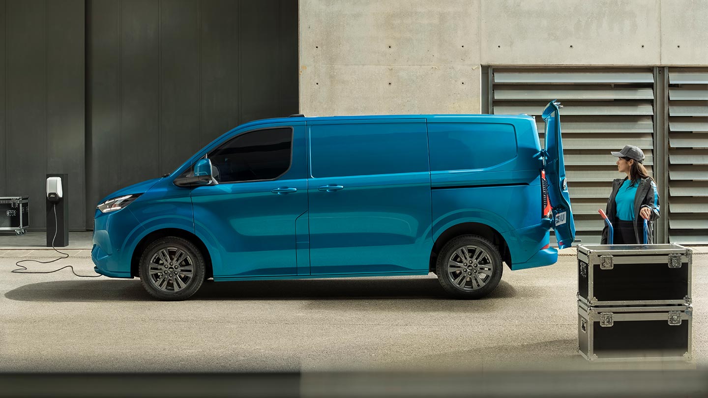Modrá elektrická dodávka Ford E-Transit Custom při nabíjení.