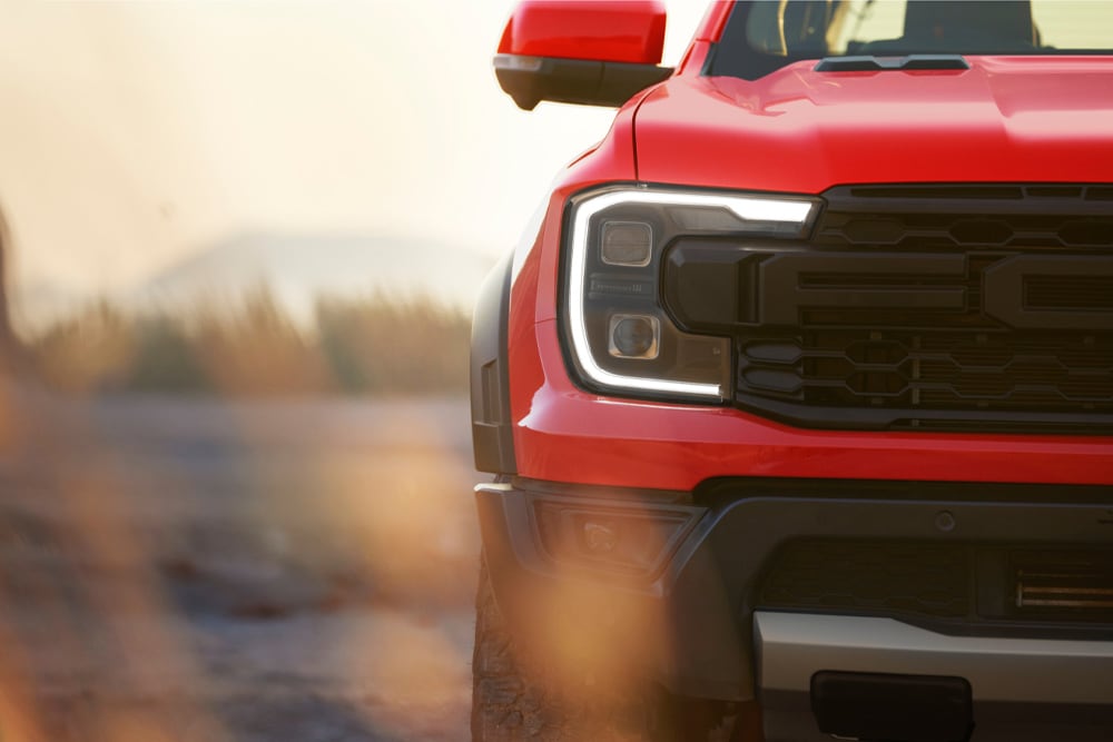 Detail přední masky červeného vozu Ford Ranger Raptor.