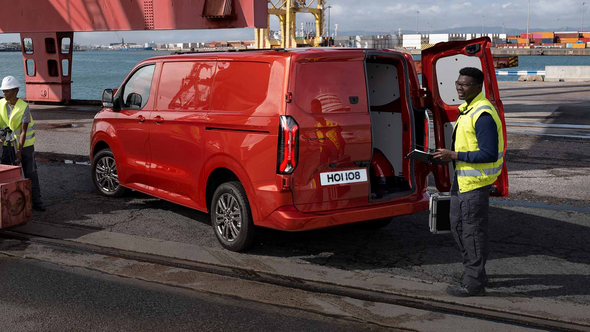 Červená dodávka Ford Transit Custom v doku.
