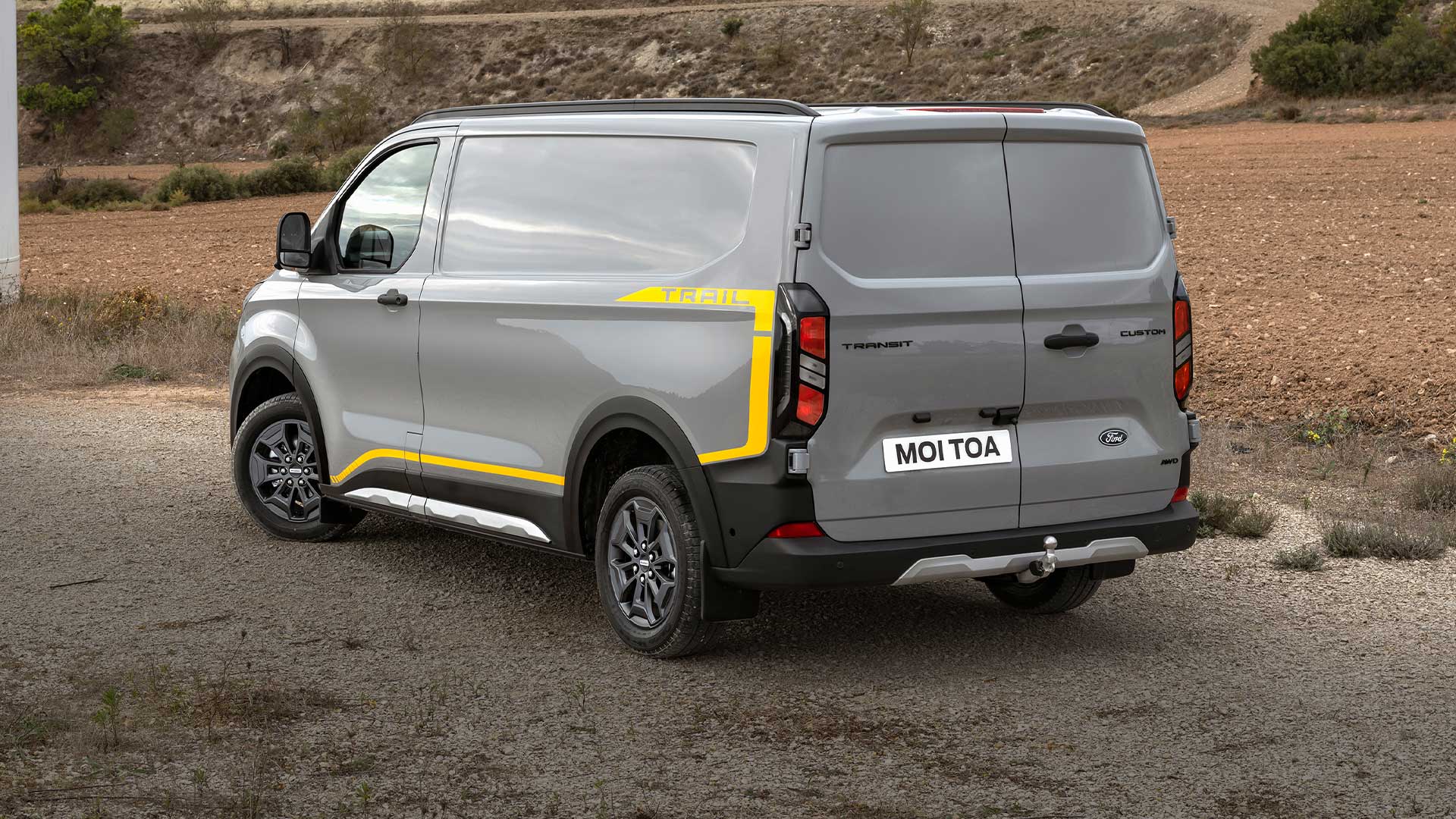 Zadní pohled na šedou dodávku Ford Transit Custom Trail.