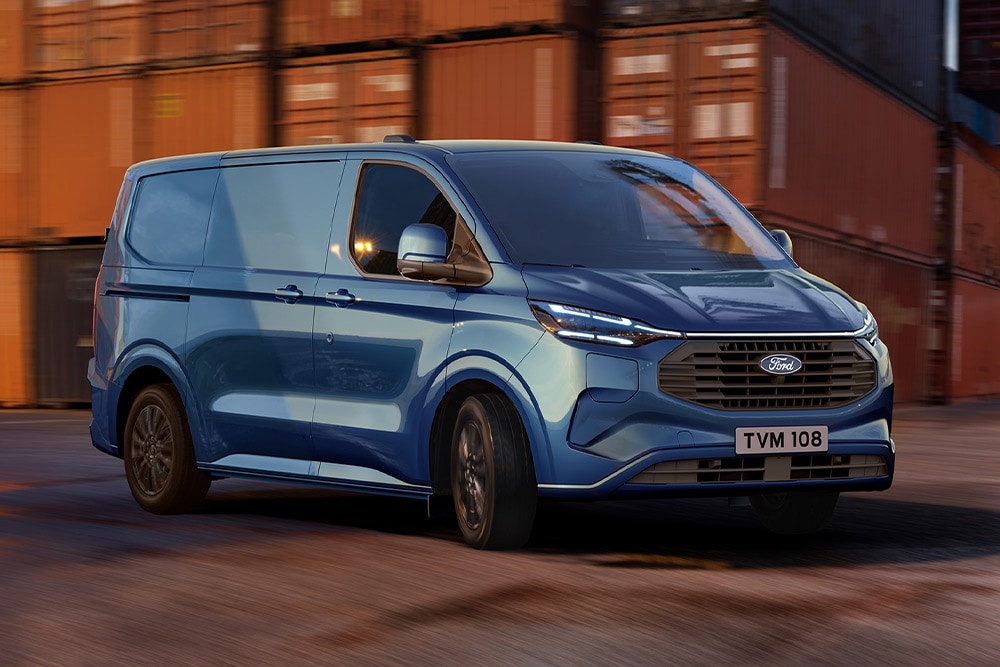 Modrý Ford Transit Custom Plug-in Hybrid projíždí přístavištěm.
