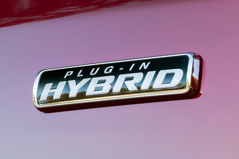 Logo „Plug-in Hybrid“ na červeném vozu Ford Transit Custom.