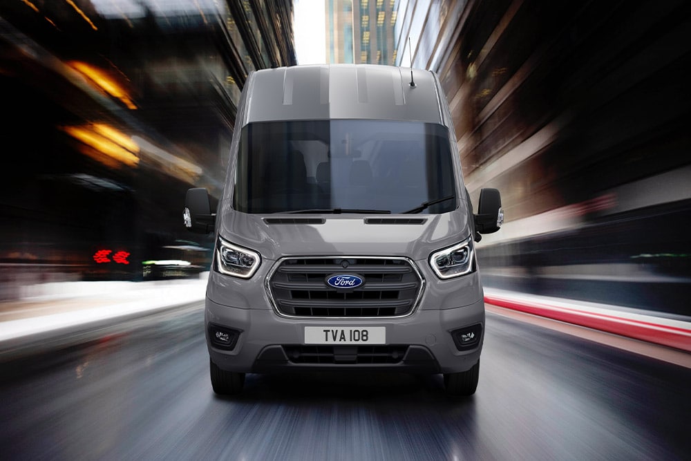 Čelní záběr na Ford Transit Van jedoucí městem.
