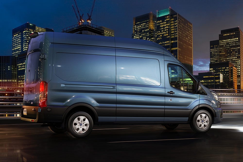 Ford Transit Van jedoucí nočním městem.