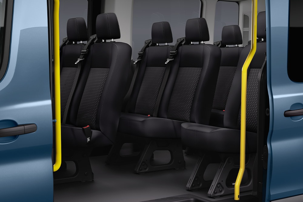 Pohled na zadní sedadla Fordu Transit Kombi přes posuvné boční dveře.