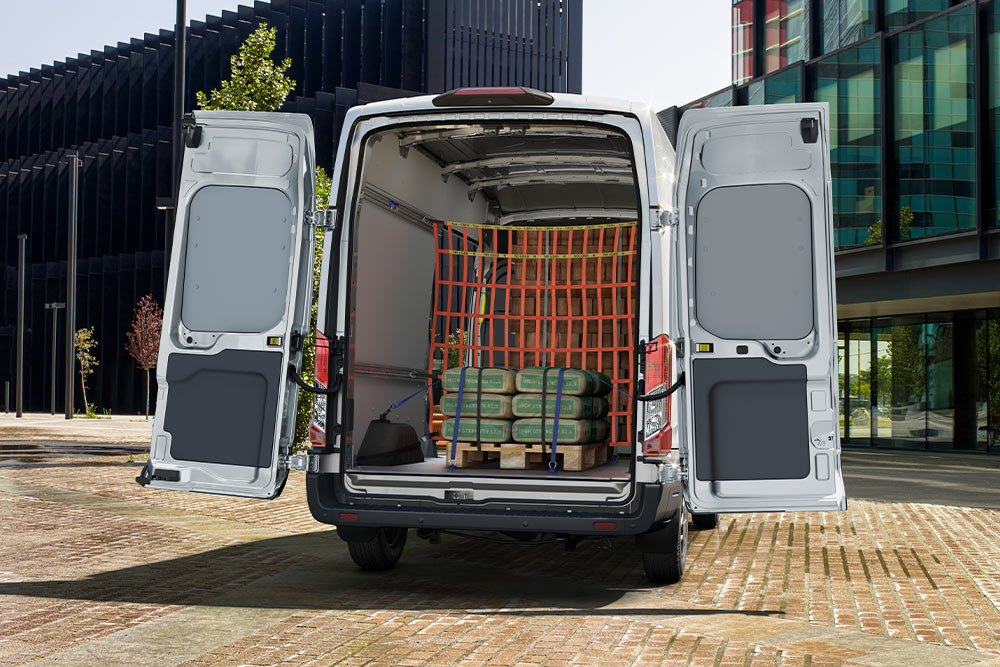 Ford Transit Double Cab s otevřenými zadními dveřmi a nákladem uvnitř.