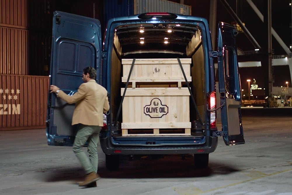 Ford Transit Van s otevřenými zadními dveřmi a nákladem uvnitř.