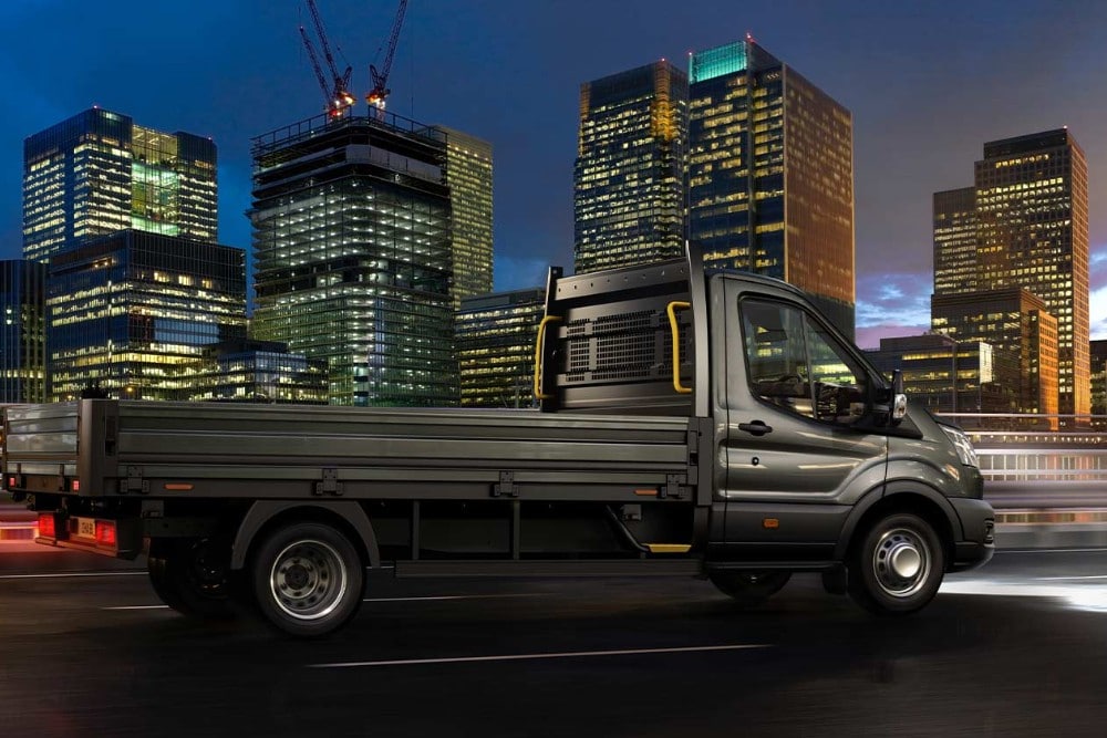 Ford Transit Podvozek projíždí ulicemi nočního města. 