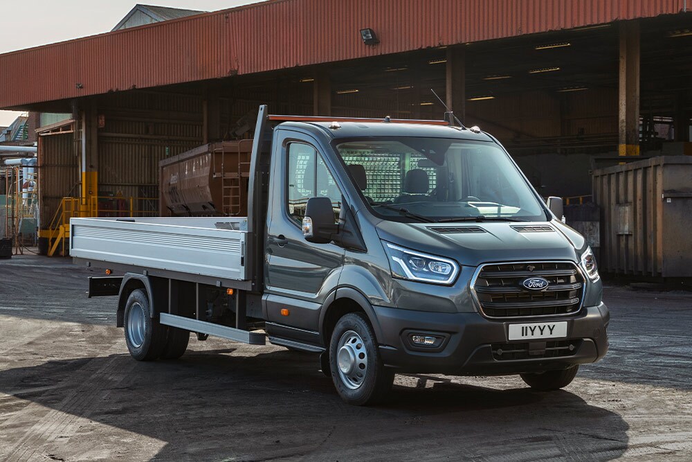 Ford Transit Podvozek s jednokabinou zaparkovaný v průmyslovém areálu. 